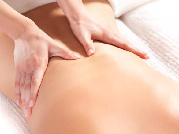 une femme se fait masser le dos après son accouchement